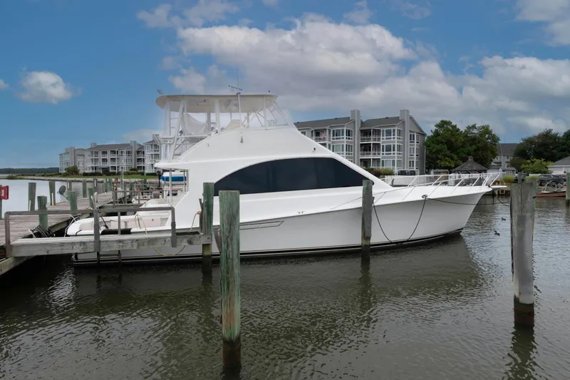The Image of 2004 Ocean Yachts 52 SUPER SPORT docked at marina, with waterfront buildings in background. - 0
