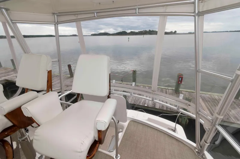 Slide: The Image of 2004 Ocean Yachts 52 SUPER SPORT helm with white seating, overlooking calm waters. - 10
