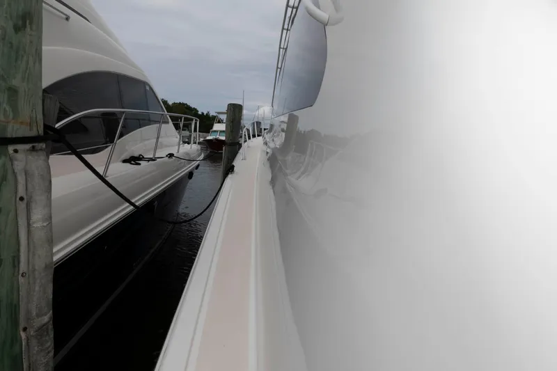 Slide: The Image of 2004 Ocean Yachts 52 SUPER SPORT docked, showcasing sleek design and reflective surface. - 18