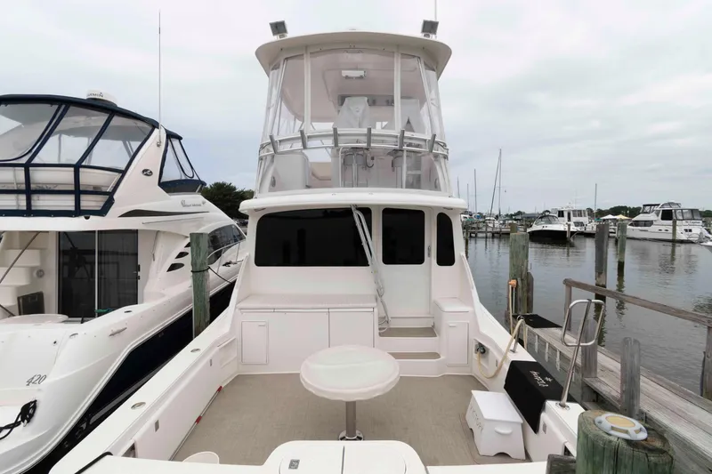 Slide: The Image of 2004 Ocean Yachts 52 SUPER SPORT docked at marina, featuring spacious deck and flybridge. - 19