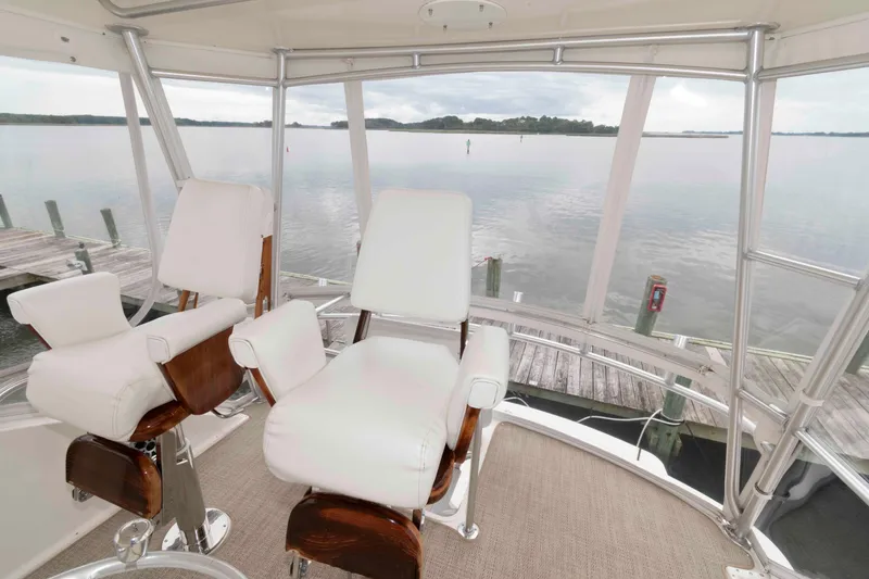 Slide: The Image of 2004 Ocean Yachts 52 SUPER SPORT helm with white captain chairs overlooking serene waters. - 9