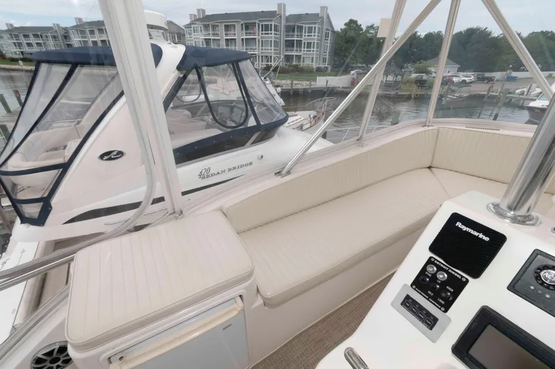 Slide: The Image of 2004 Ocean Yachts 52 Super Sport interior with seating and control panel, docked near waterfront buildings. - 14