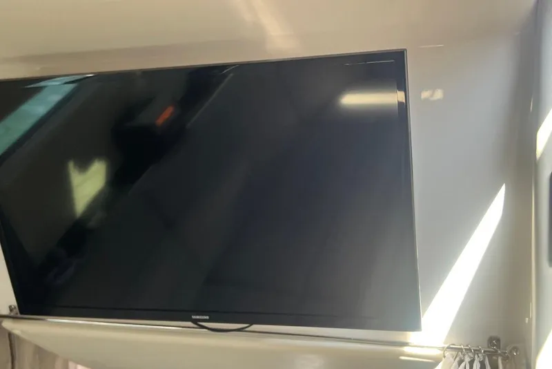 Slide: The Image of Flat-screen TV inside 2017 Regal 35 Sport Coupe yacht interior. - 19