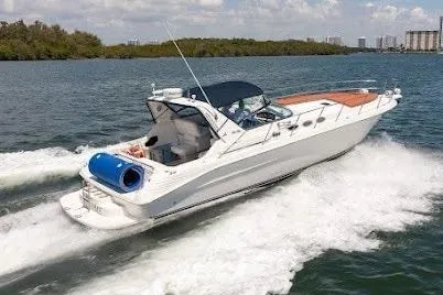 Slide: The Image of 1997 Sea Ray 400 Express Cruiser speeding on water, scenic background. - 11