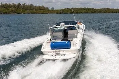 Slide: The Image of 1997 Sea Ray 400 Express Cruiser speeding on water, surrounded by lush greenery. - 12