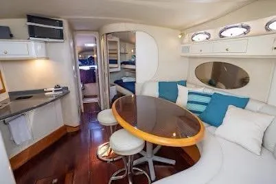 Slide: The Image of 1997 Sea Ray 400 Express Cruiser interior with dining area, plush seating, and modern amenities. - 16
