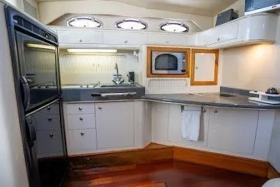 Slide: The Image of 1997 Sea Ray 400 Express Cruiser kitchen with modern appliances and sleek cabinetry. - 17