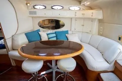 Slide: The Image of 1997 Sea Ray 400 Express Cruiser interior with curved seating and round table. - 20