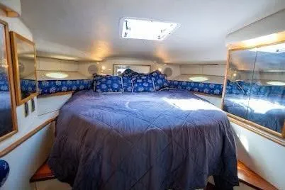 Slide: The Image of 1997 Sea Ray 400 Express Cruiser cabin with cozy bed and nautical decor. - 23