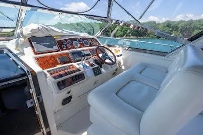 Slide: The Image of 1997 Sea Ray 400 Express Cruiser helm with leather seating and control panel. - 25