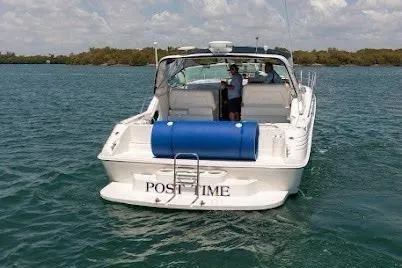 Slide: The Image of 1997 Sea Ray 400 Express Cruiser on water, rear view with blue fender. - 3
