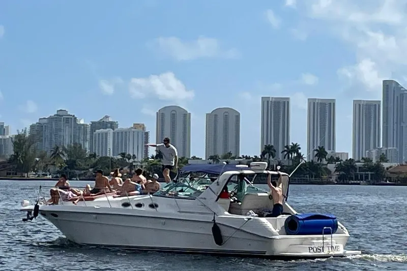 Slide: The Image of 1997 Sea Ray 400 Express Cruiser with people enjoying a sunny day on the water. - 6