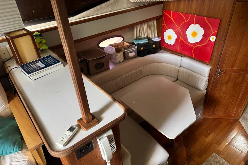 Slide: The Image of 1990 Carver 3608 Aft Cabin interior with cozy seating and vibrant floral artwork. - 10