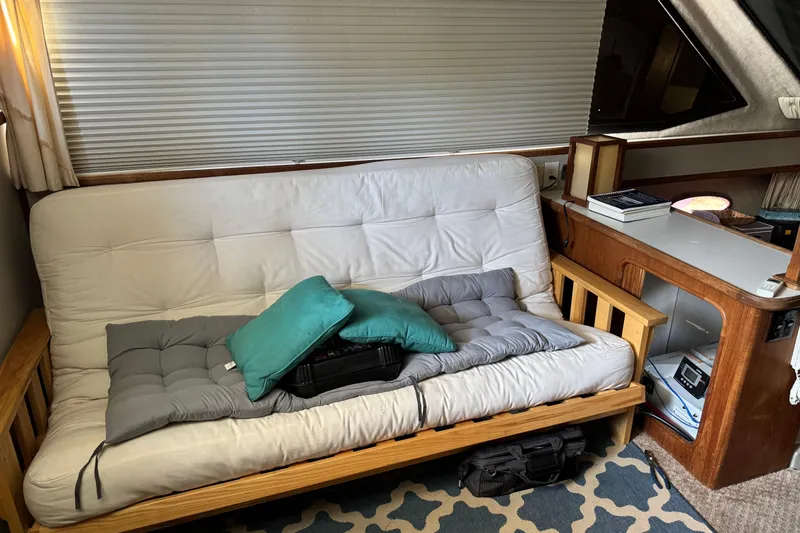 Slide: The Image of Interior of 1990 Carver 3608 Aft Cabin with futon, cushions, and wooden cabinetry. - 12