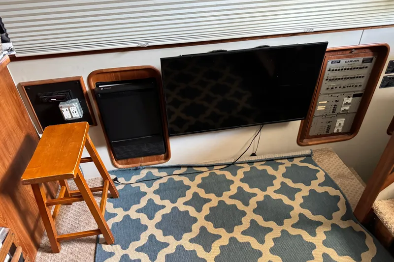 Slide: The Image of Interior of 1990 Carver 3608 Aft Cabin with TV, control panel, and patterned rug. - 11
