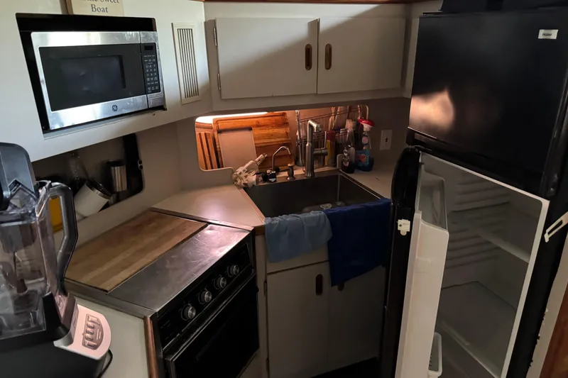 Slide: The Image of Compact kitchen in a 1990 Carver 3608 Aft Cabin boat with appliances and storage. - 13
