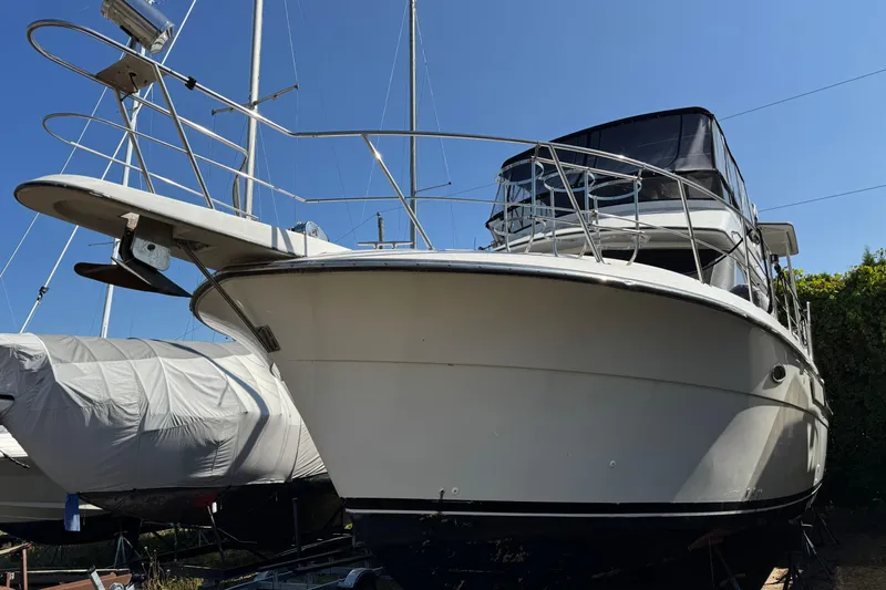 Slide: The Image of 1990 Carver 3608 Aft Cabin yacht on land, viewed from the front. - 2