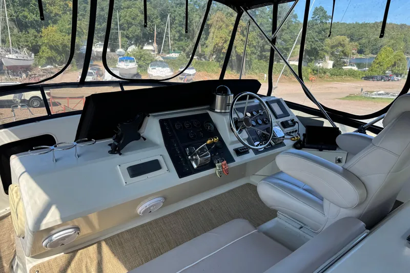 Slide: The Image of 1990 Carver 3608 Aft Cabin helm with steering wheel, controls, and navigation equipment. - 8