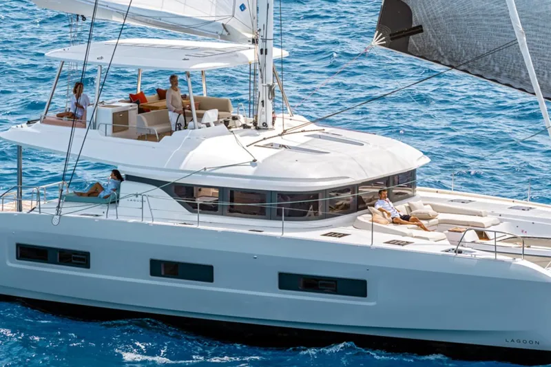 The Image of 2026 Lagoon 55 yacht sailing with passengers on a sunny day. - 1