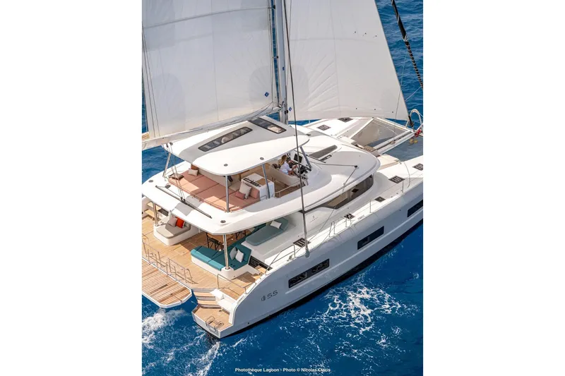 Slide: The Image of Luxurious 2026 Lagoon 55 yacht sailing on clear blue ocean waters. - 10