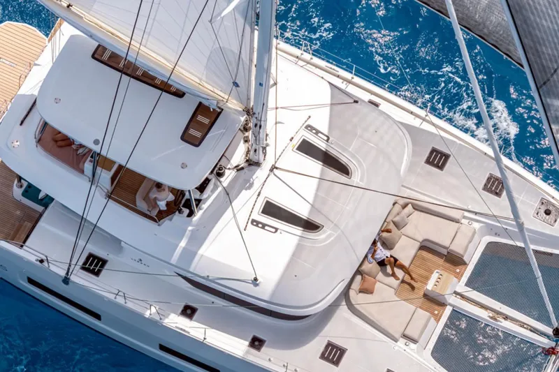 Slide: The Image of Aerial view of 2026 Lagoon 55 yacht sailing on clear blue water. - 2