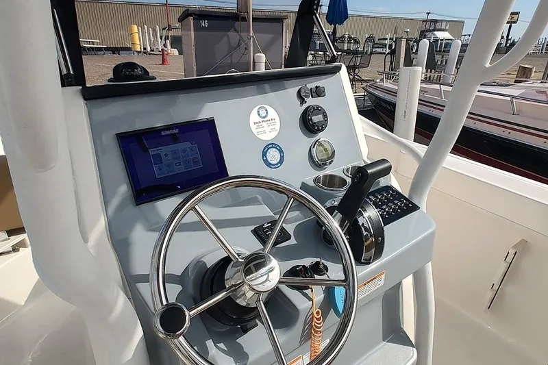 Slide: The Image of 2024 Bayliner Trophy T24CC helm with steering wheel and navigation controls. - 12
