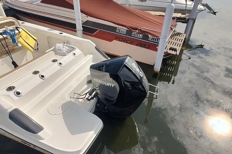 Slide: The Image of 2024 Bayliner Trophy T24CC with Mercury outboard motor docked beside another boat. - 6