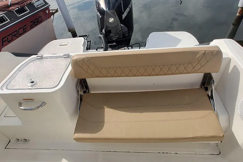 Slide: The Image of 2024 Bayliner Trophy T24CC boat interior with tan seating and livewell. - 9
