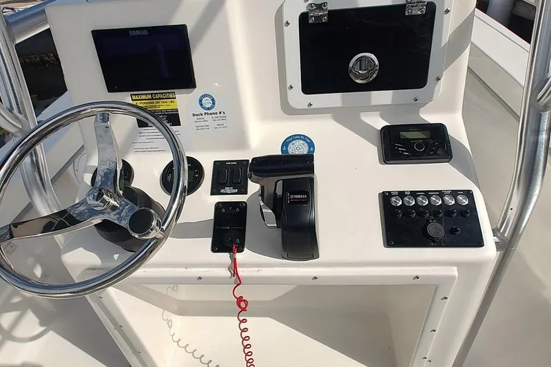 Slide: The Image of 2024 May-Craft 23 Cape Classic boat dashboard with steering wheel and control panel. - 5