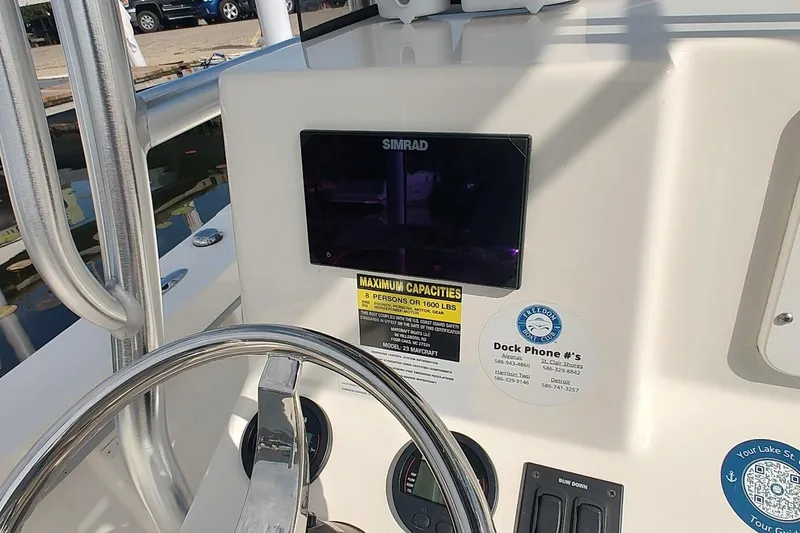 Slide: The Image of 2024 May-Craft 23 Cape Classic boat dashboard with steering wheel and Simrad display. - 8