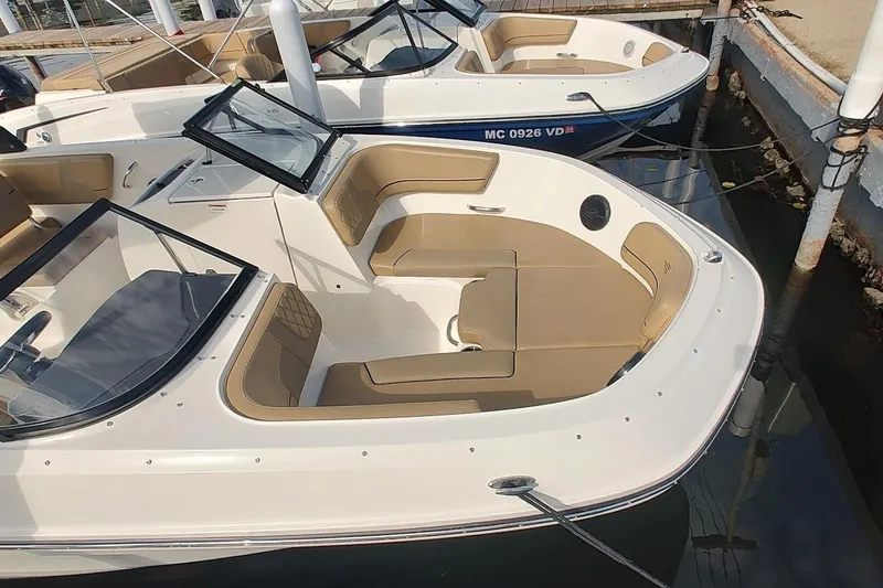 Slide: The Image of 2024 Bayliner VR6 Bowrider OB with tan seating, docked in marina. - 2
