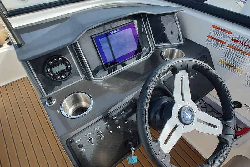 Slide: The Image of 2025 Bayliner VR6 Bowrider OB dashboard with steering wheel and control panel. - 6