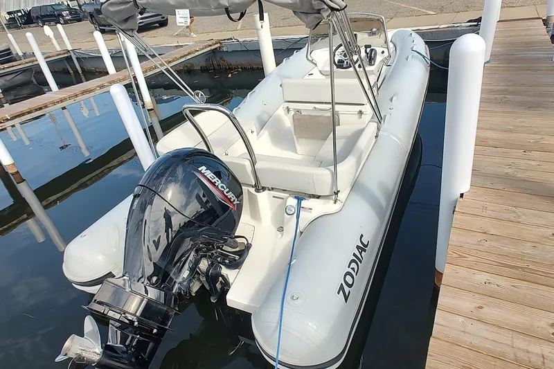 Slide: The Image of 2024 Zodiac N-ZO 680 inflatable boat docked with Mercury outboard motor. - 2