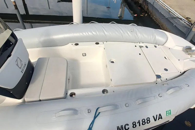 Slide: The Image of 2024 Zodiac N-ZO 680 boat interior with white seating and storage compartments. - 4