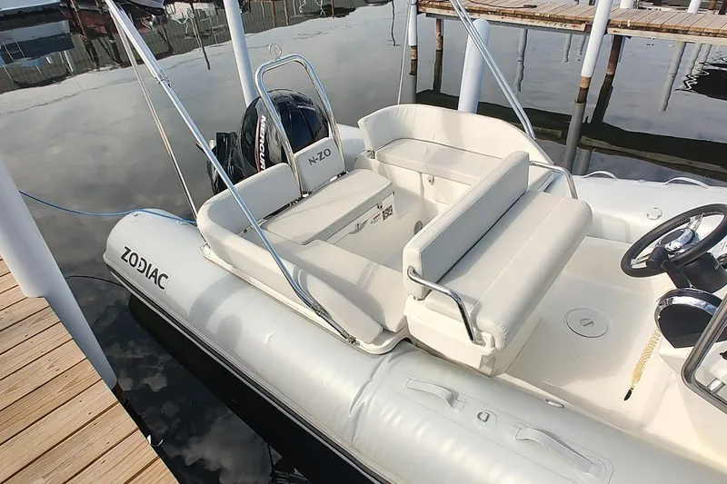 Slide: The Image of 2024 Zodiac N-ZO 680 boat with sleek seating and modern design at a dock. - 7