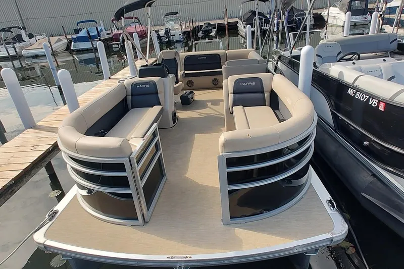 The Image of 2024 Harris Cruiser 230 pontoon boat docked, featuring spacious seating and modern design. - 0