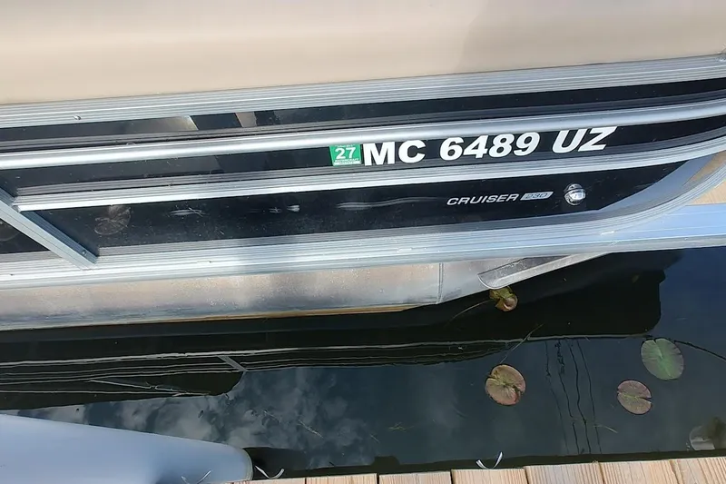Slide: The Image of 2024 Harris Cruiser 230 pontoon boat docked with registration number MC 6489 UZ. - 11