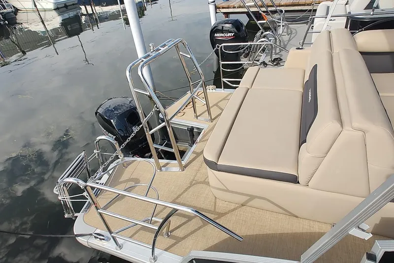 Slide: The Image of 2024 Harris Cruiser 230 boat with beige seating and stainless steel railings. - 3