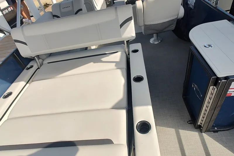 Slide: The Image of 2023 Crest Classic LX 220 boat interior with cushioned seating and cup holders. - 11