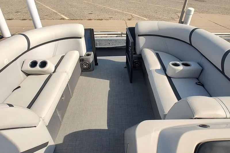 Slide: The Image of 2023 Crest Classic LX 220 pontoon boat interior with plush seating and cup holders. - 2