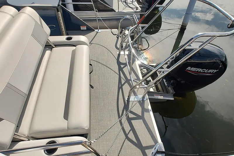 Slide: The Image of 2023 Crest Classic LX 220 pontoon boat with Mercury engine and comfortable seating. - 5