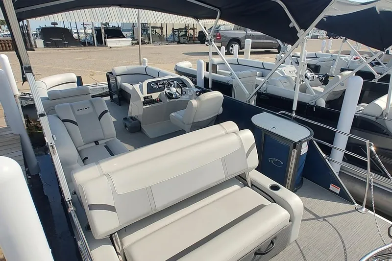 Slide: The Image of 2023 Crest Classic LX 220 pontoon boat with spacious seating and modern helm. - 7