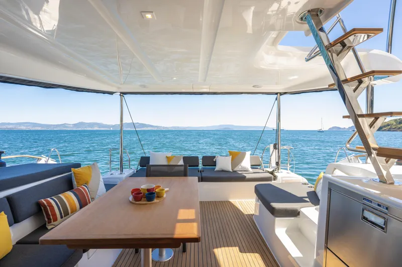 Slide: The Image of Luxurious 2026 Lagoon 43 yacht interior with ocean view, featuring comfortable seating and vibrant cushions. - 3