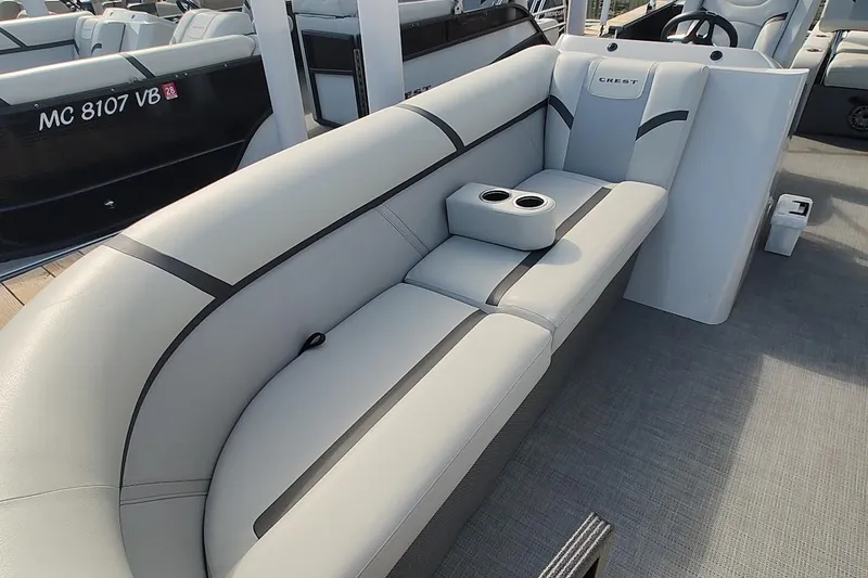 Slide: The Image of 2024 Crest Classic LX 220 pontoon boat interior with plush seating and cup holders. - 10