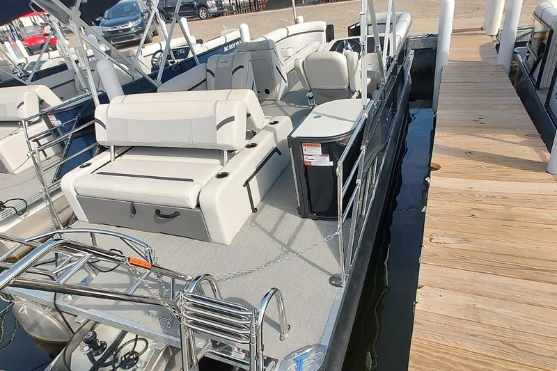 Slide: The Image of 2024 Crest Classic LX 220 pontoon boat docked, featuring spacious seating and modern design. - 2