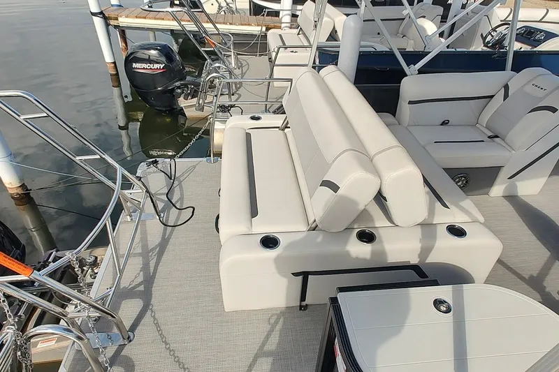 Slide: The Image of 2024 Crest Classic LX 220 pontoon boat with comfortable seating and Mercury outboard motor. - 3
