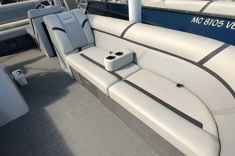 Slide: The Image of 2024 Crest Classic LX 220 boat interior with plush seating and cup holders. - 4
