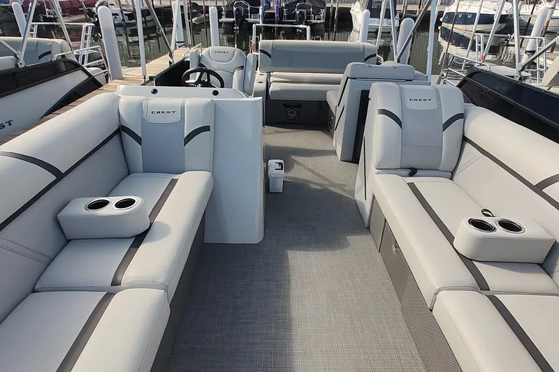Slide: The Image of 2024 Crest Classic LX 220 pontoon boat interior with luxurious seating and cup holders. - 6