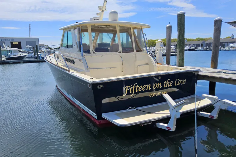 The Image of 2009 Sabre 42 Express yacht cruising on a serene lake with lush green shoreline. - 0