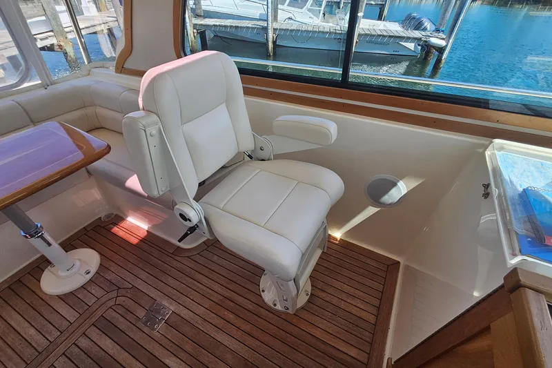 Slide: The Image of 2009 Sabre 42 Express boat docked, showcasing spacious deck and seating area. - 14